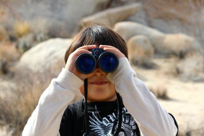 Visuel enfant regardant à travers des jumelles